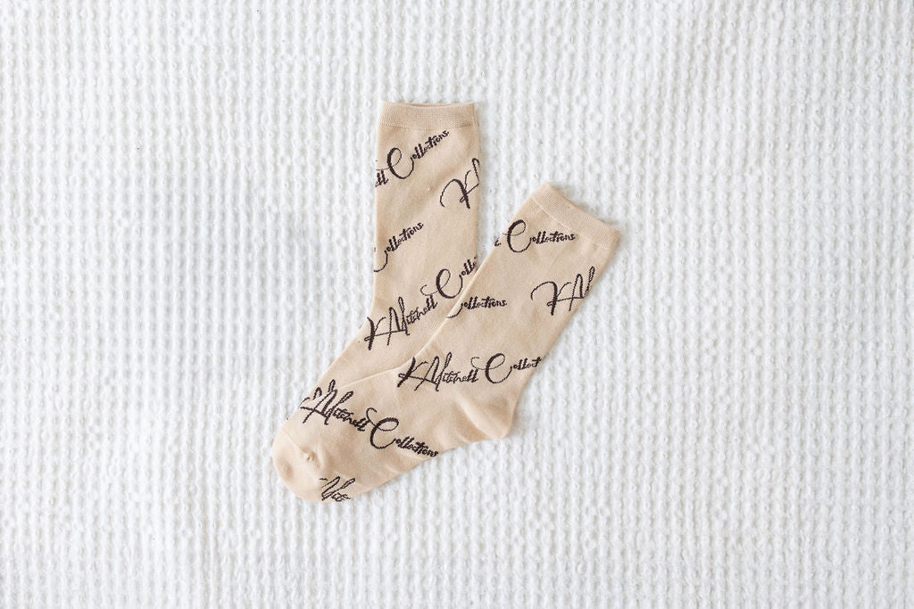 Pair of tan socks laying on white background
