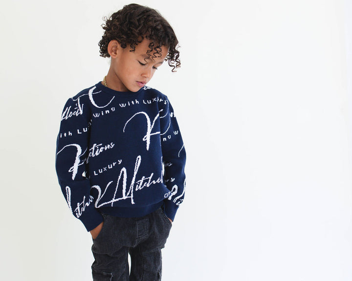 Child wearing a navy sweater with white text on a light gray background