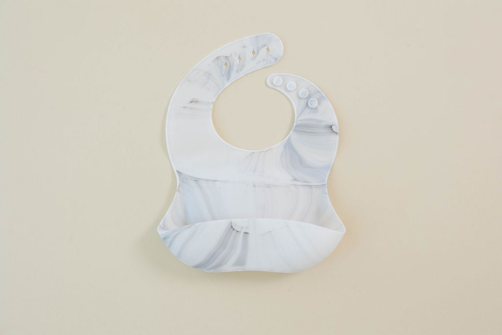 Baby bib with marble pattern on a beige background